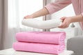 Woman stacking clean towels on table