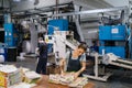 Woman stacking magazines on print shop