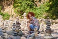 Woman stacking pebbles on a river bed