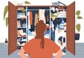 Woman stand in front of messy untidy wardrobe. Person look at open closet full of disordered clothes and accessories