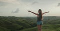 Woman stand on green hill meadow, raised hands Royalty Free Stock Photo