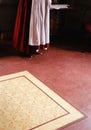 A woman stand in a red colonial dress and apron in the Captain William Smith house