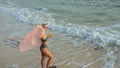 Woman stand on a reef rock stone in sea on sunset. Girl on beach Royalty Free Stock Photo