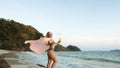 Woman stand on a reef rock stone in sea on sunset. Girl on beach Royalty Free Stock Photo