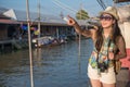 Woman stand on river bank and point to the front