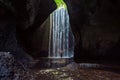 Woman stand under cave waterfall Royalty Free Stock Photo