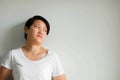 A woman standing against the wall with loneliness, feeling depressed and dispirited on white background