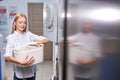 woman standing alone with clean towels in the self serviced laundry with dryer machines Royalty Free Stock Photo