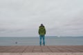 Woman standing alone on pier looking at sea at cold winter day in Tallinn Estonia Royalty Free Stock Photo