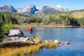 Woman standing along Sprague Lake in Rocky Mountain National Park in Autumn Royalty Free Stock Photo