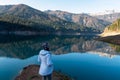 Sauris - Woman standing at alpine lake Sauris (Lago di Sauris) in Friuli Venezia Giulia, Italy