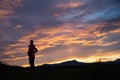 Woman standing on and ascent in beautiful nature under glowing evening sky