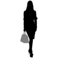 Woman is standing with a bag and skirt