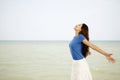 Woman standing on beach with her arms outstretched Royalty Free Stock Photo