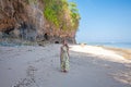 Woman standing on the beach near the rocks and the sea Royalty Free Stock Photo