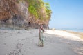 Woman standing on the beach near the rocks and the sea Royalty Free Stock Photo