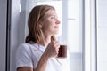 Woman Standing By Bedroom Window And drinking fresh coffee Royalty Free Stock Photo