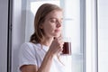 Woman Standing By Bedroom Window And drinking fresh coffee Royalty Free Stock Photo