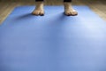 Woman standing on blue yoga mat. Feet with pink pedicure, low perspective Royalty Free Stock Photo