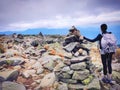 A woman standing by cairn on Mt. Washington