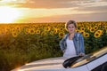 Woman Standing Beside Car in Sunflower Field