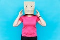 Woman standing with a cardboard on her head with angry face. Emotions concept.