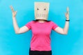 Woman standing with a cardboard on her head with angry face. Emotions concept.