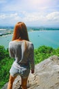 Woman standing on the cliff and see something on the blue sky, blue sea and cloud Royalty Free Stock Photo
