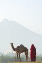 Woman standing close to her camel