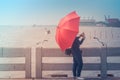 Woman standing on concrete bridge, she holding red umbrella and taking photo seagulls at Bangpu Recreation Center.