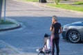 Woman standing on the corner with her child in a stroller and a car turning in front of her in Gentilly neighborhood Royalty Free Stock Photo