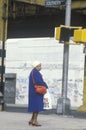 Woman standing on corner in poor neighborhood