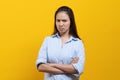 Woman standing crossed arms and stare at camera isolated on yellow background Royalty Free Stock Photo