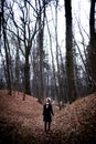 Woman standing in dark cold forest background Royalty Free Stock Photo
