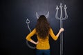 Woman standing with devils horns and trident drawn on blackboard Royalty Free Stock Photo