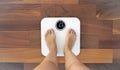 Woman standing on a digital scale with body fat analyzer