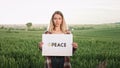 Woman standing in field, protesting against war.