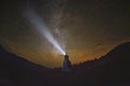Woman is standing in the forest and pointing the Milky Way
