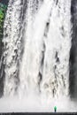 Woman standing in front of gigantic Skogafoss waterfall in Iceland Royalty Free Stock Photo