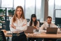 Woman is standing in front of her colleagues. Business people in formal clothes are working in the office together Royalty Free Stock Photo