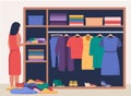 Woman standing in front of opened closet with apparel hanging inside and pile of clothes on floor. Cleaning throwing things home Royalty Free Stock Photo