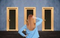 Woman standing in front of similar doors. Choice concept Royalty Free Stock Photo