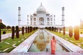 A woman standing front of Taj Mahal when sun rise.