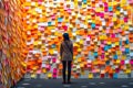 A woman standing in front of a wall full of sticky notes, neural network generated photorealistic image Royalty Free Stock Photo