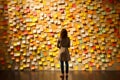 A woman standing in front of a wall full of sticky notes, neural network generated photorealistic image Royalty Free Stock Photo