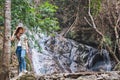 A woman standing in front of waterfall in the jungle Royalty Free Stock Photo