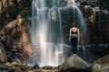 Woman standing in front of a waterfall. Royalty Free Stock Photo