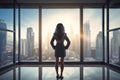 Woman Standing in Front of Window, Looking Out at City Royalty Free Stock Photo