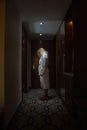 Woman standing, head bowed, in the Hallway