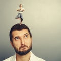 Woman standing on the head of thoughtful man Royalty Free Stock Photo